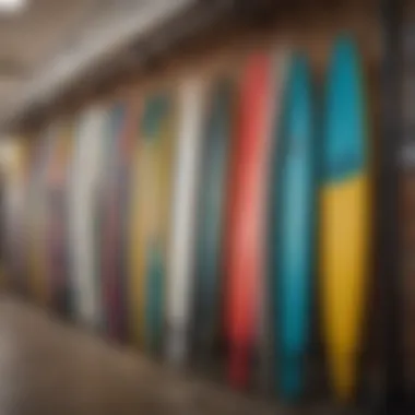 A vibrant collection of used foil surfboards displayed on a rack, showcasing various designs and colors.