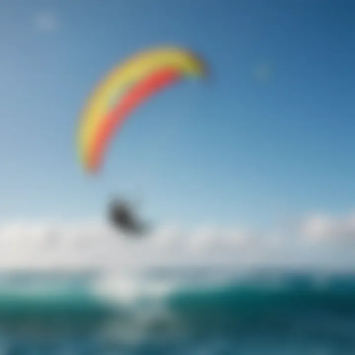 Kiteboarder gliding over the waves with vibrant kite colors against a blue sky