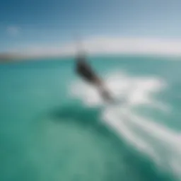 A breathtaking aerial shot of a kiteboarder gliding over turquoise waves.