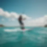 A scenic view of a vibrant kiteboarder gliding across turquoise waters with a catamaran in the background.