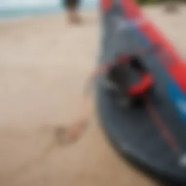 A close-up of essential kiteboarding gear displayed on the sandy beach