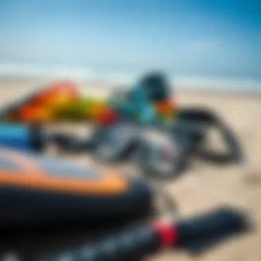 Close-up of essential kitesurfing gear laid out on the sandy beach.